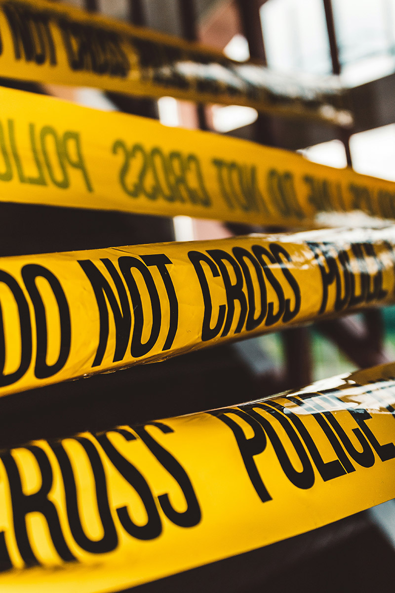 A yellow tape with "DO NOT CROSS POLICE" stamped on it.